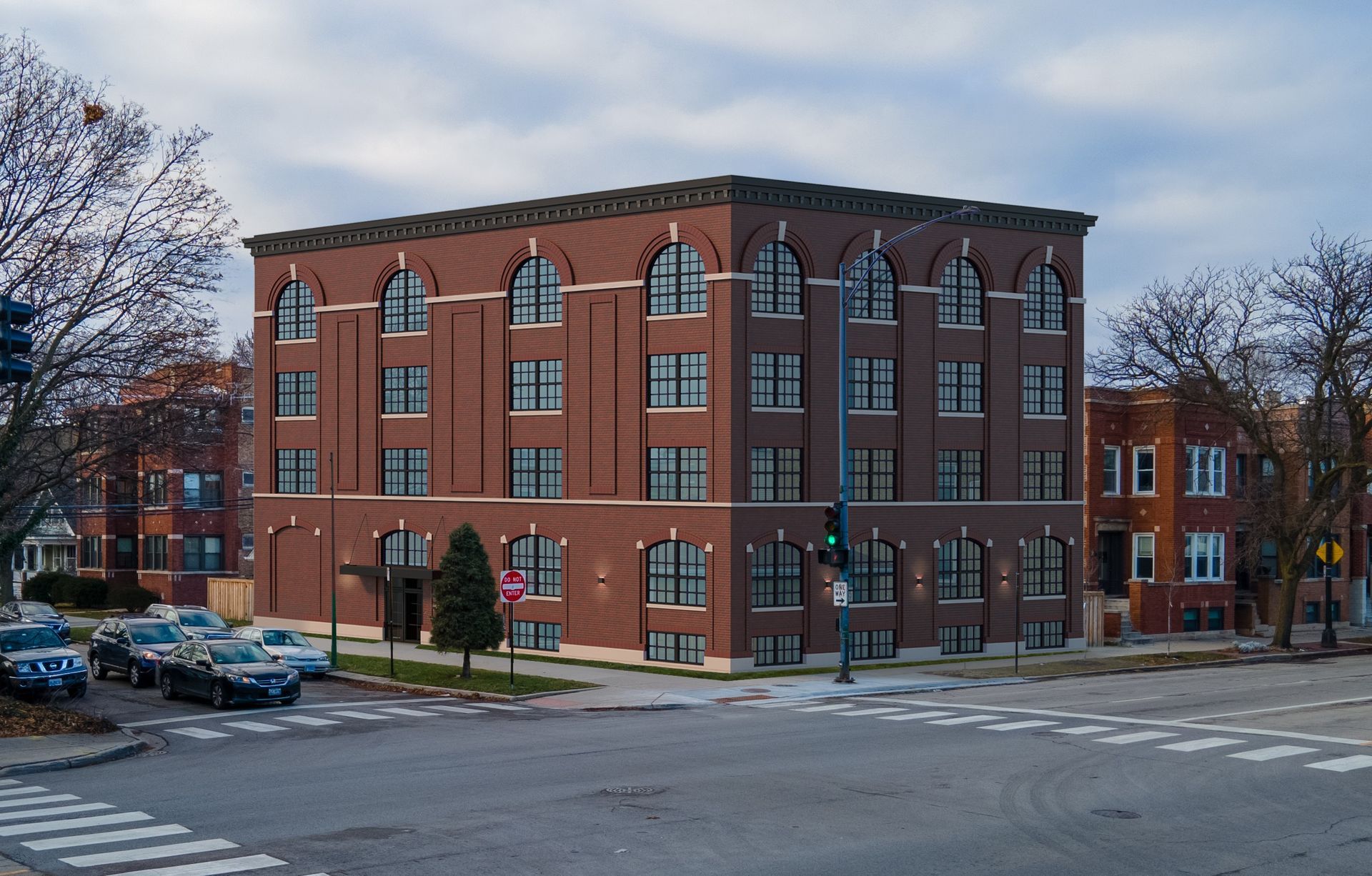 A large brick building sits on the corner of a city street