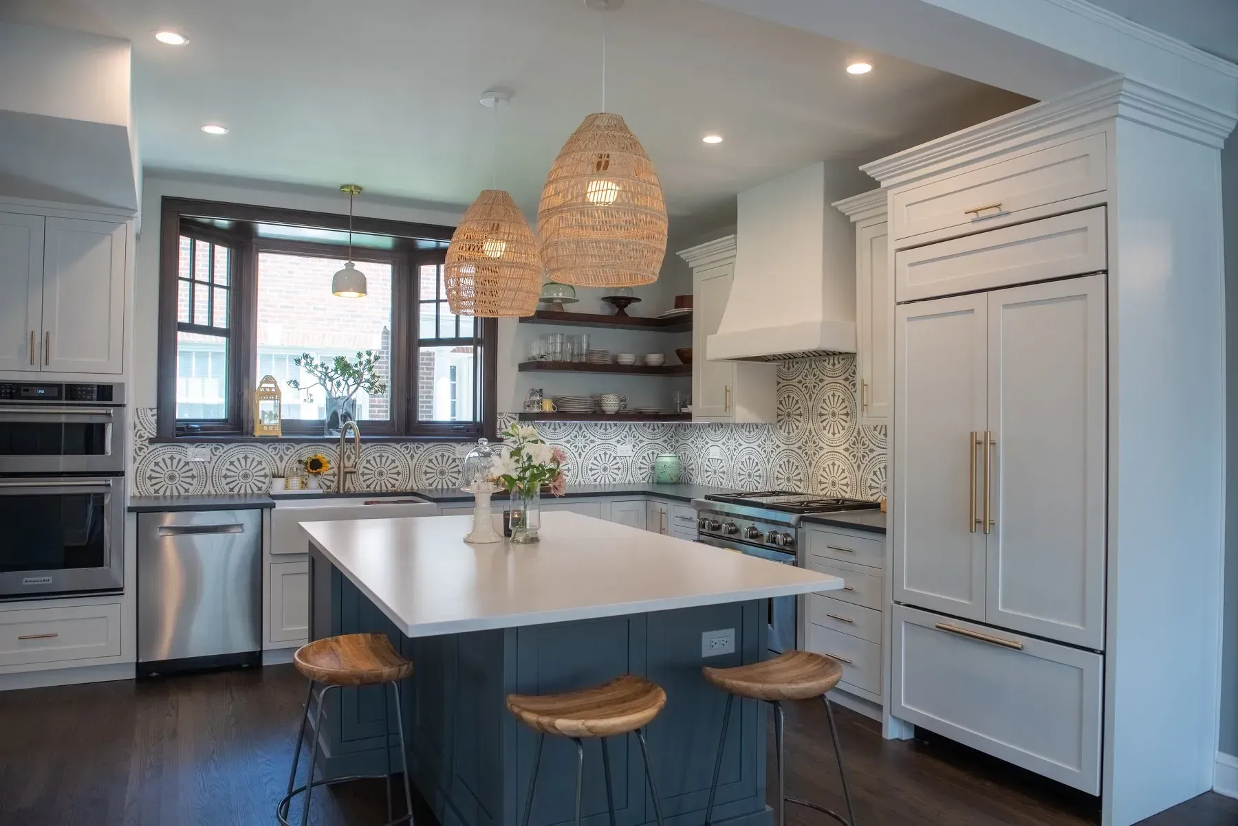 A kitchen with white cabinets , stainless steel appliances , and a large island.