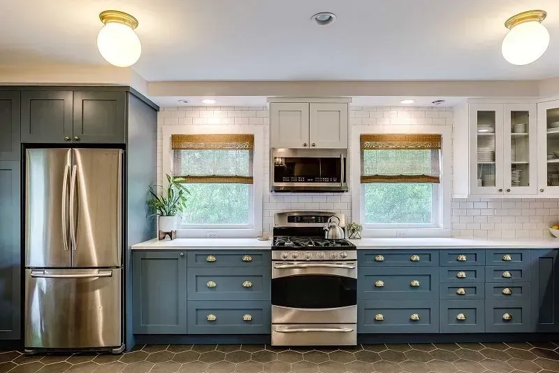 A kitchen with stainless steel appliances and blue cabinets.