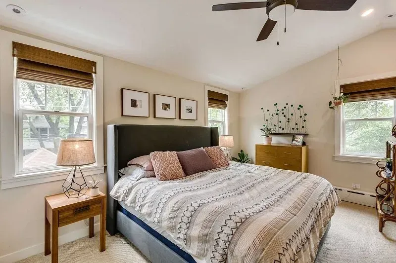 A bedroom with a king size bed and a ceiling fan.