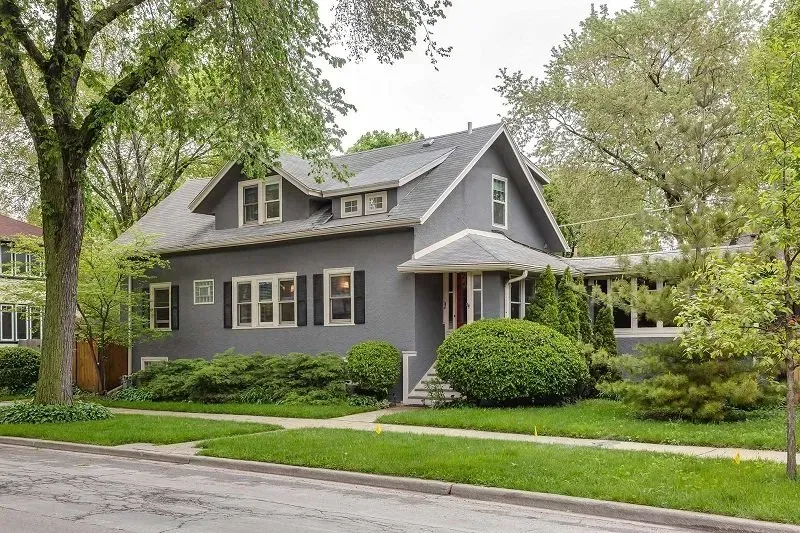 A gray house with white shutters on the windows