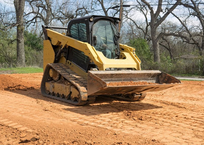 Two yellow road rollers grading a dirt road in a rural construction site Two yellow road rollers grading a dirt road in a rural construction site