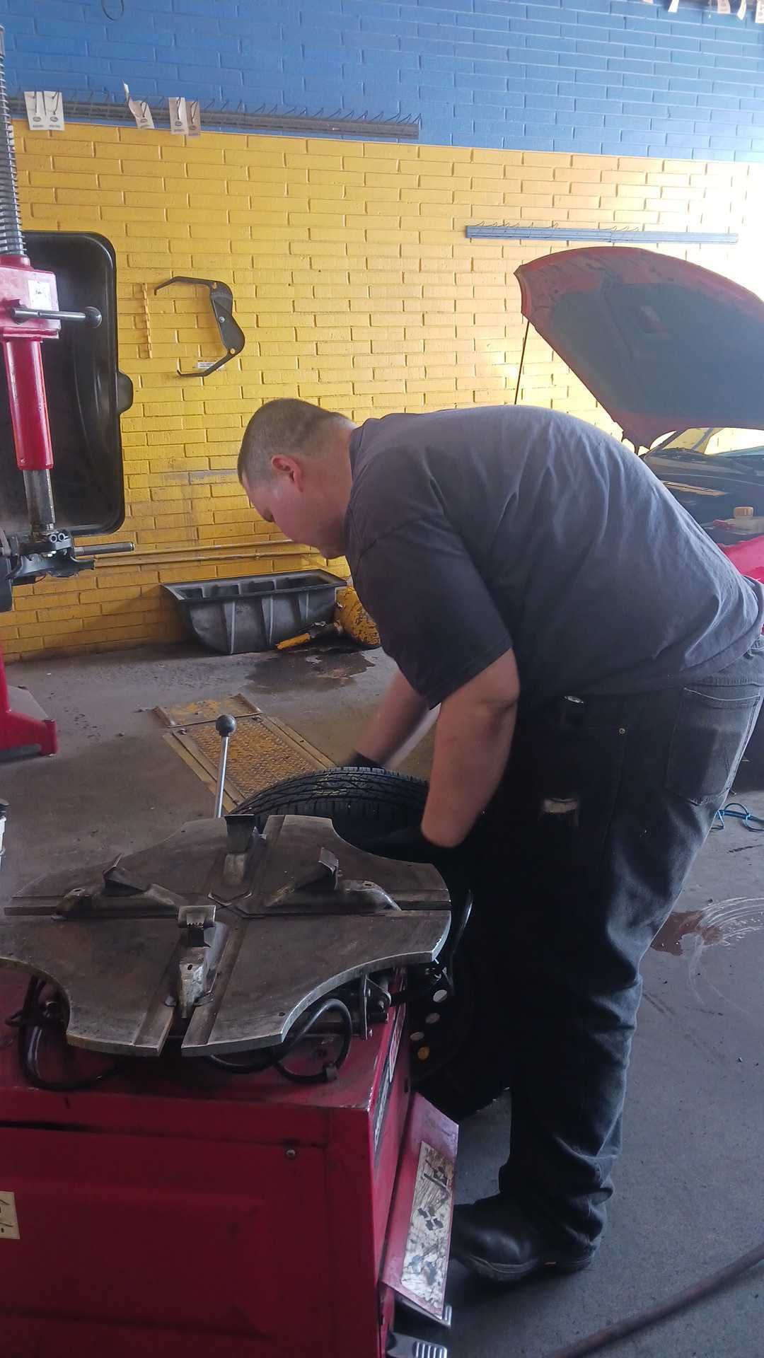 Mechanic Working on a Tire | Mango Automotive