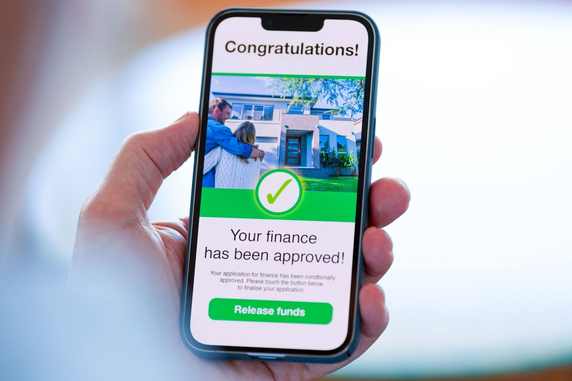 A person is holding a cell phone with a congratulations message on the screen.