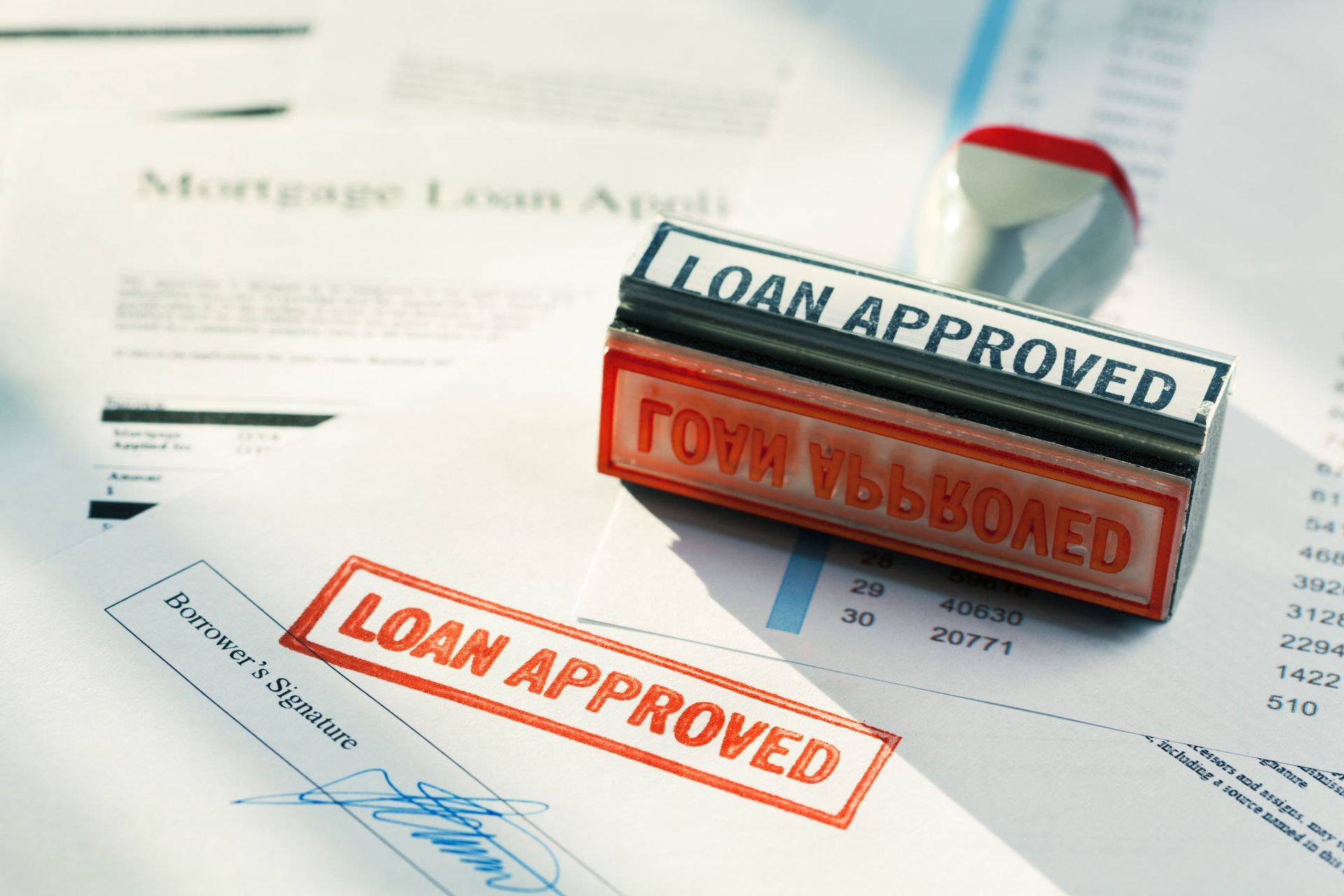 Two stamps on a piece of paper that say loan approved