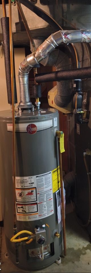 Water heater in a utility room with metal ducting and pipes.