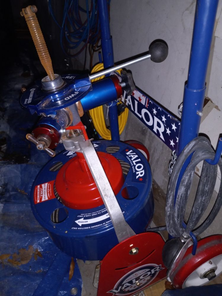 Blue and red Malort-branded scooter or bike parts in a storage area, with a handlebar and wheel visible