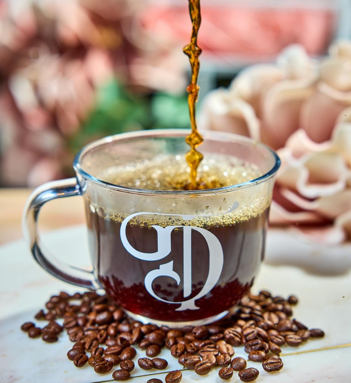 Coffee pouring into a clear mug with a large