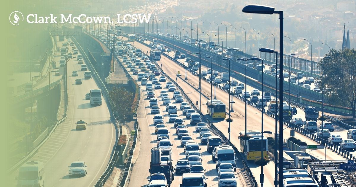 Heavy traffic on a snowy highway under a greenish sky, with cars packed in multiple lanes.