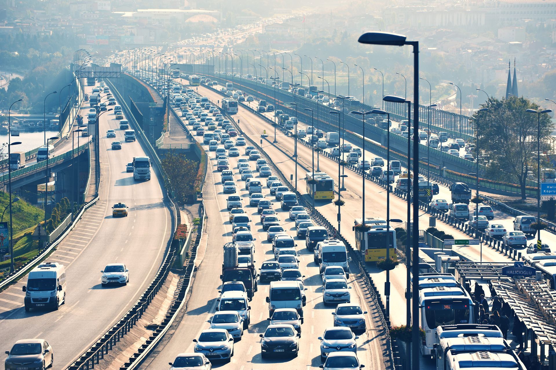 Heavy traffic jam on a multi-lane highway under a hazy sky, with cars packed in both directions.