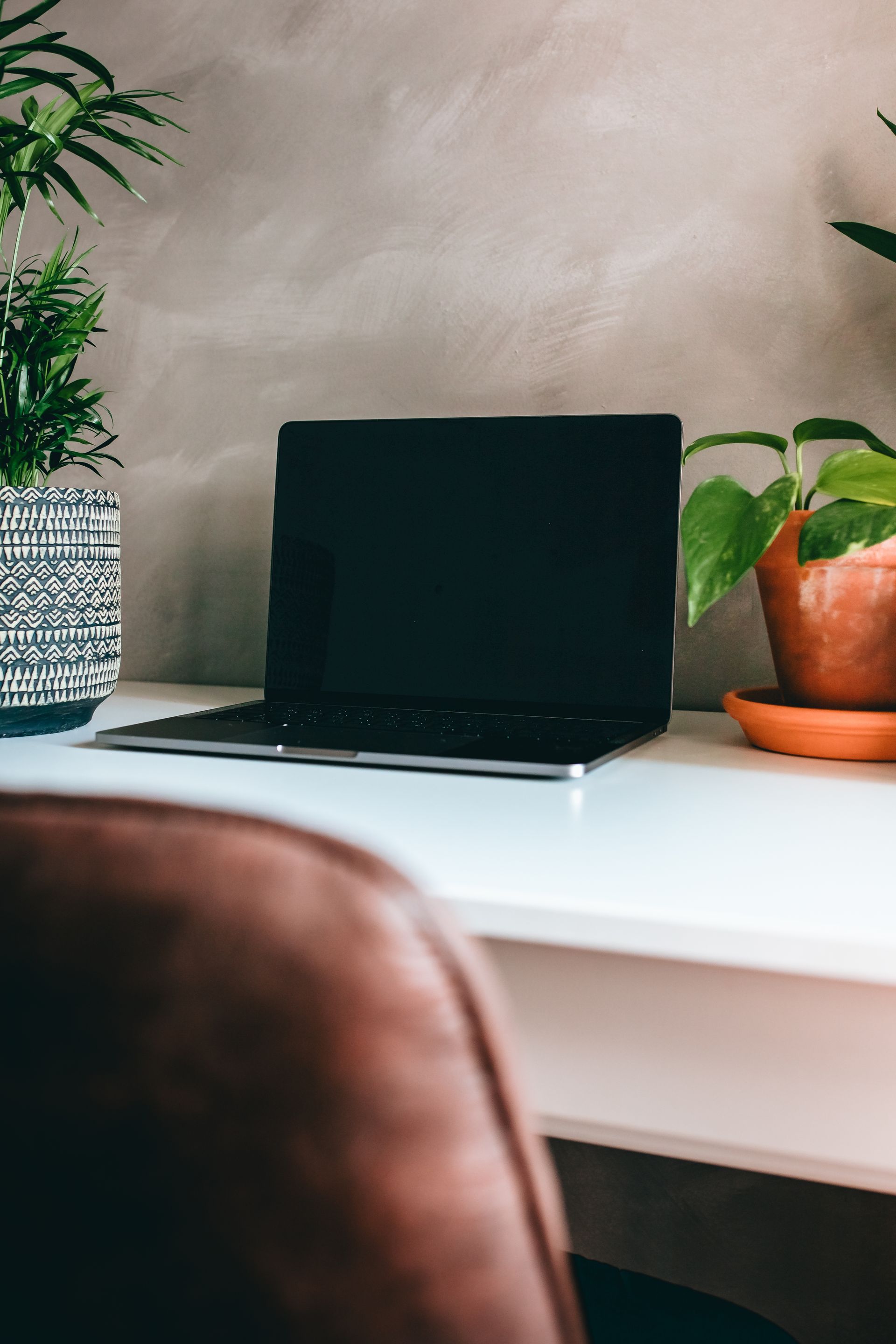 Two people relaxing on a couch and using a laptop in a bright living room