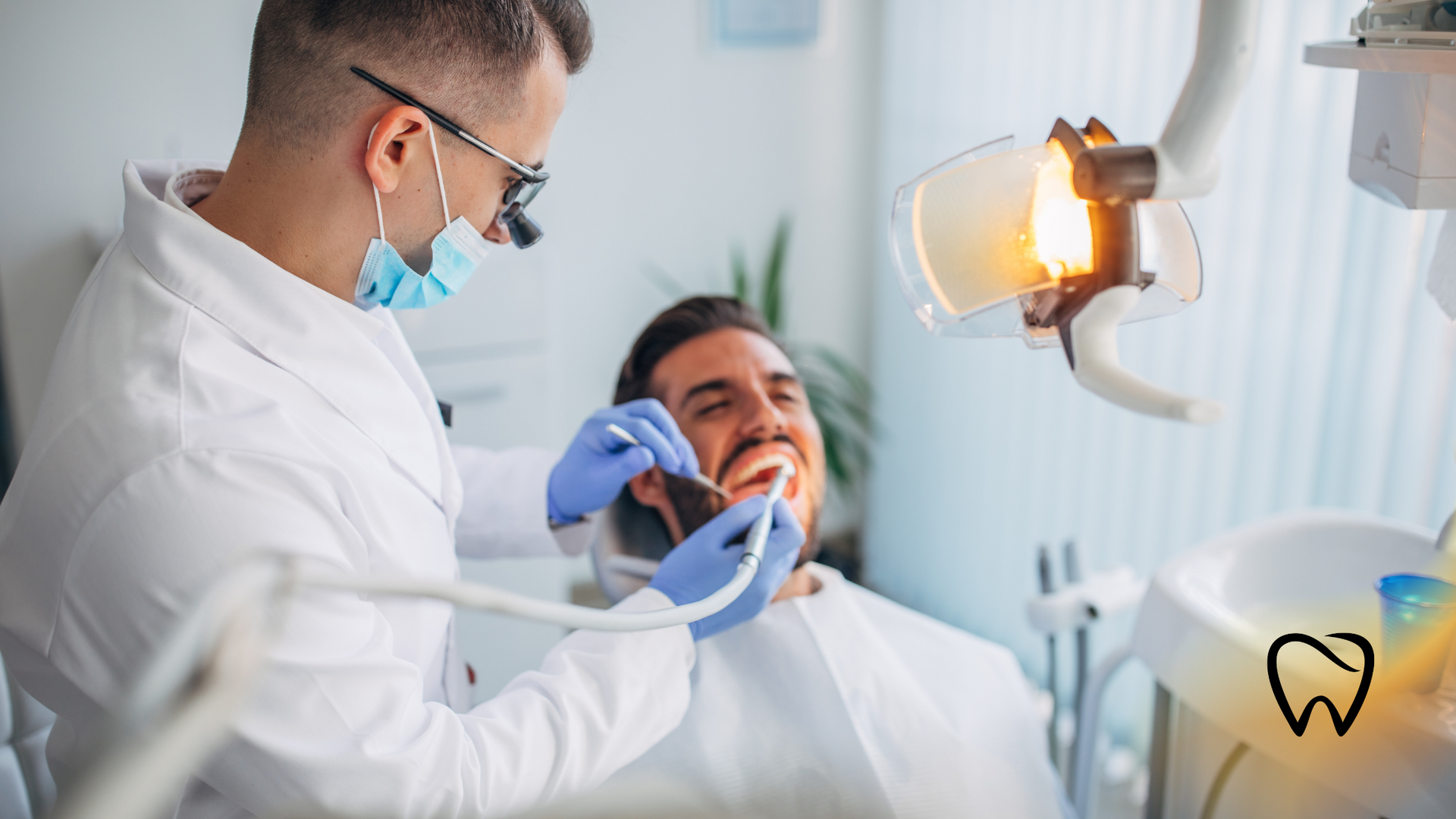 Dentist examining a patient's teeth with tools under bright examination light in a dental office.