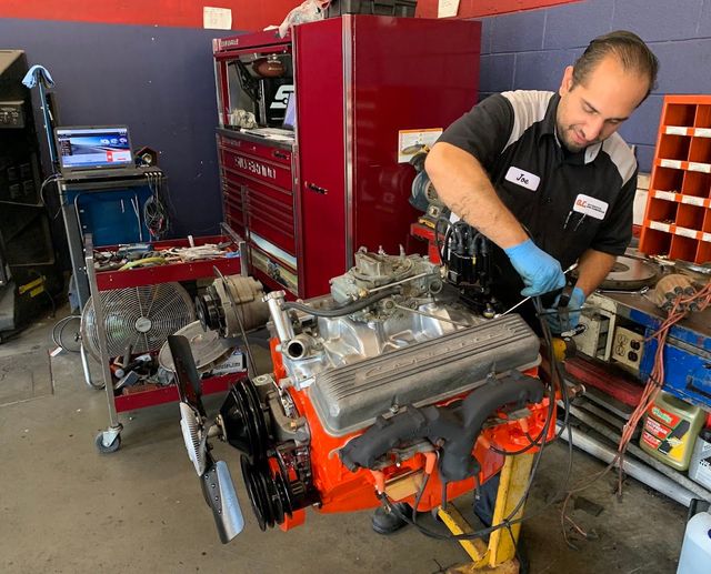 Mechanic working on a car engine in a garage | O.C. Automotive and Diagnostics