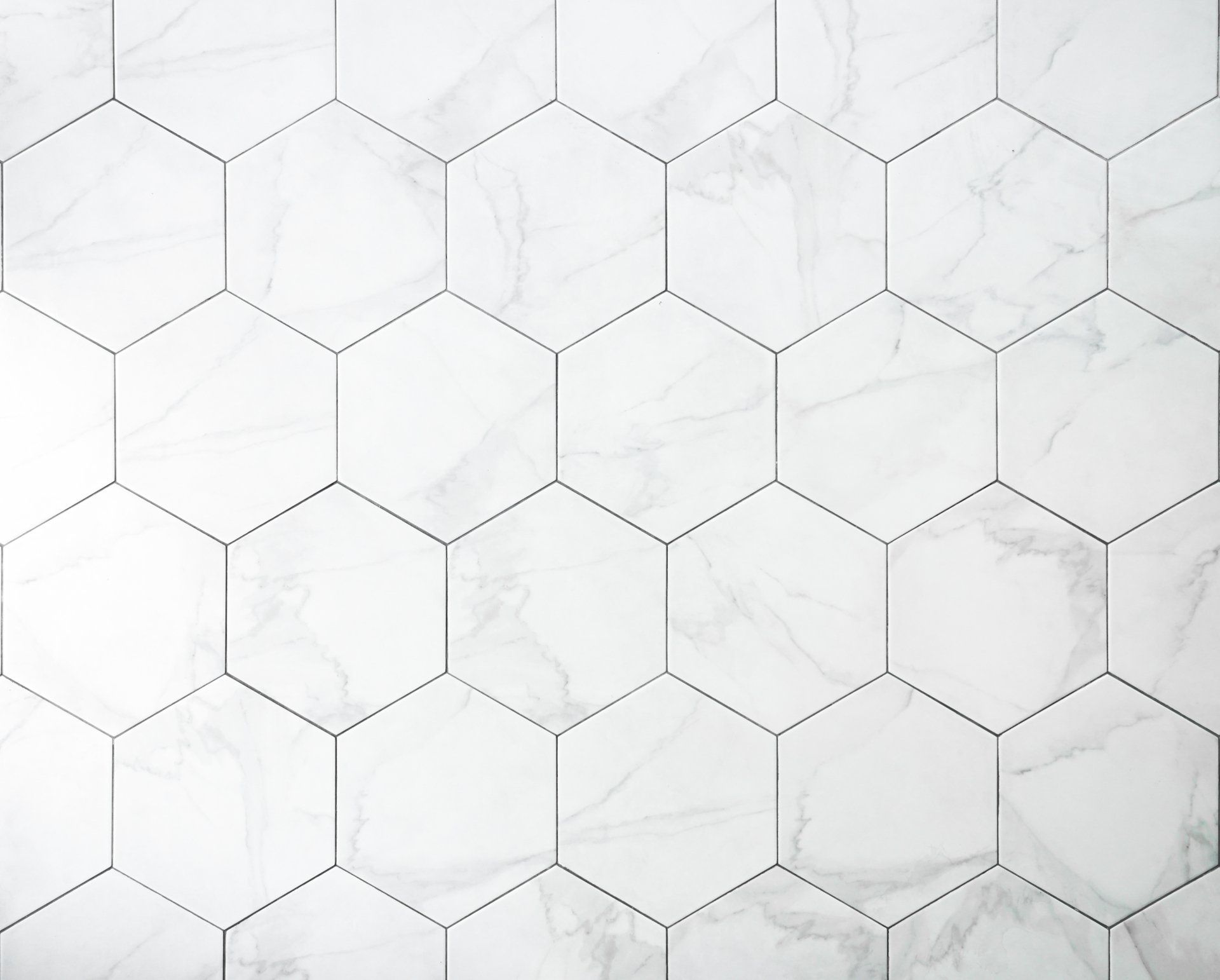 White hexagonal tile pattern with light gray marble-like veining