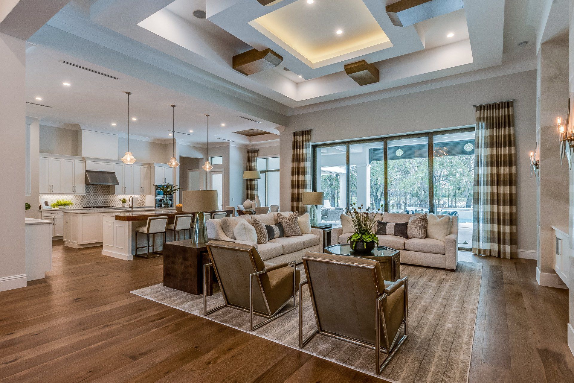Bright modern living room with sectional sofa, chairs, dining table, and kitchen in open floor plan