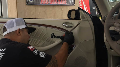 Car interior with black leather seats, dashboard, steering wheel, and center console in a luxury sports car