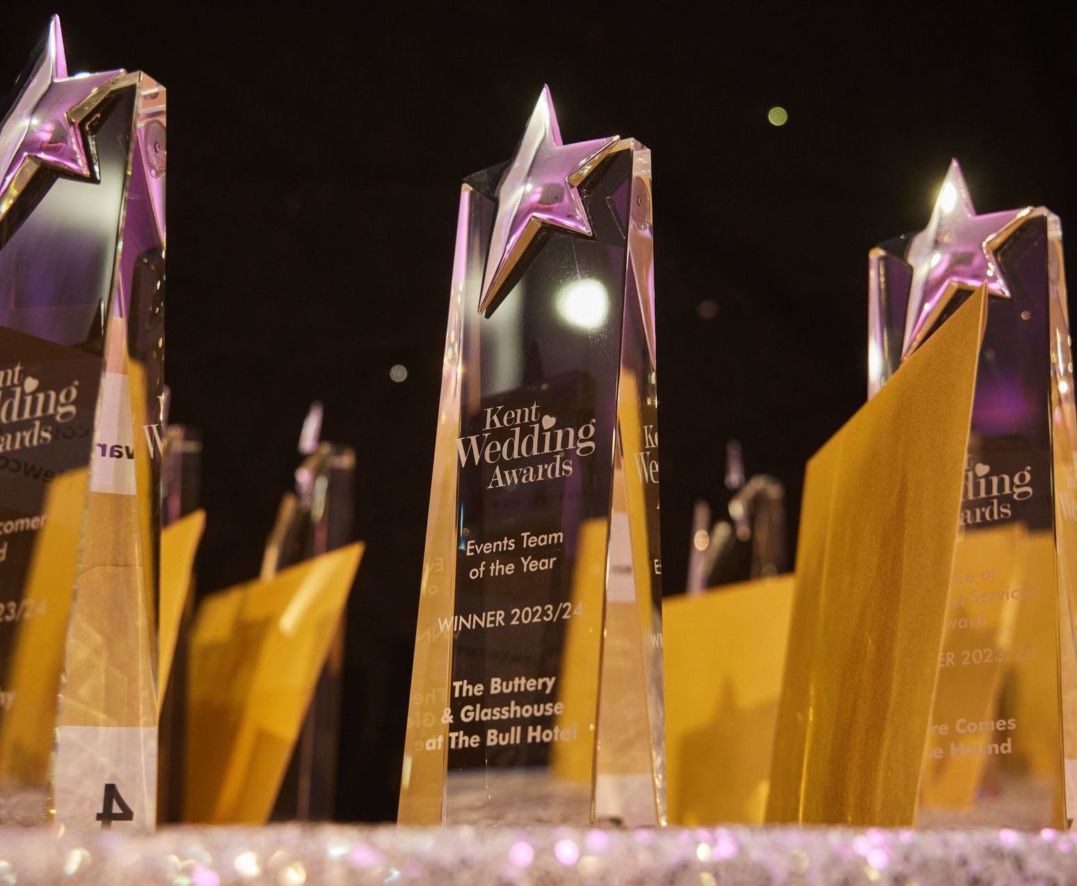 Gold-and-purple star-topped awards on display at a ceremony banquet table.
