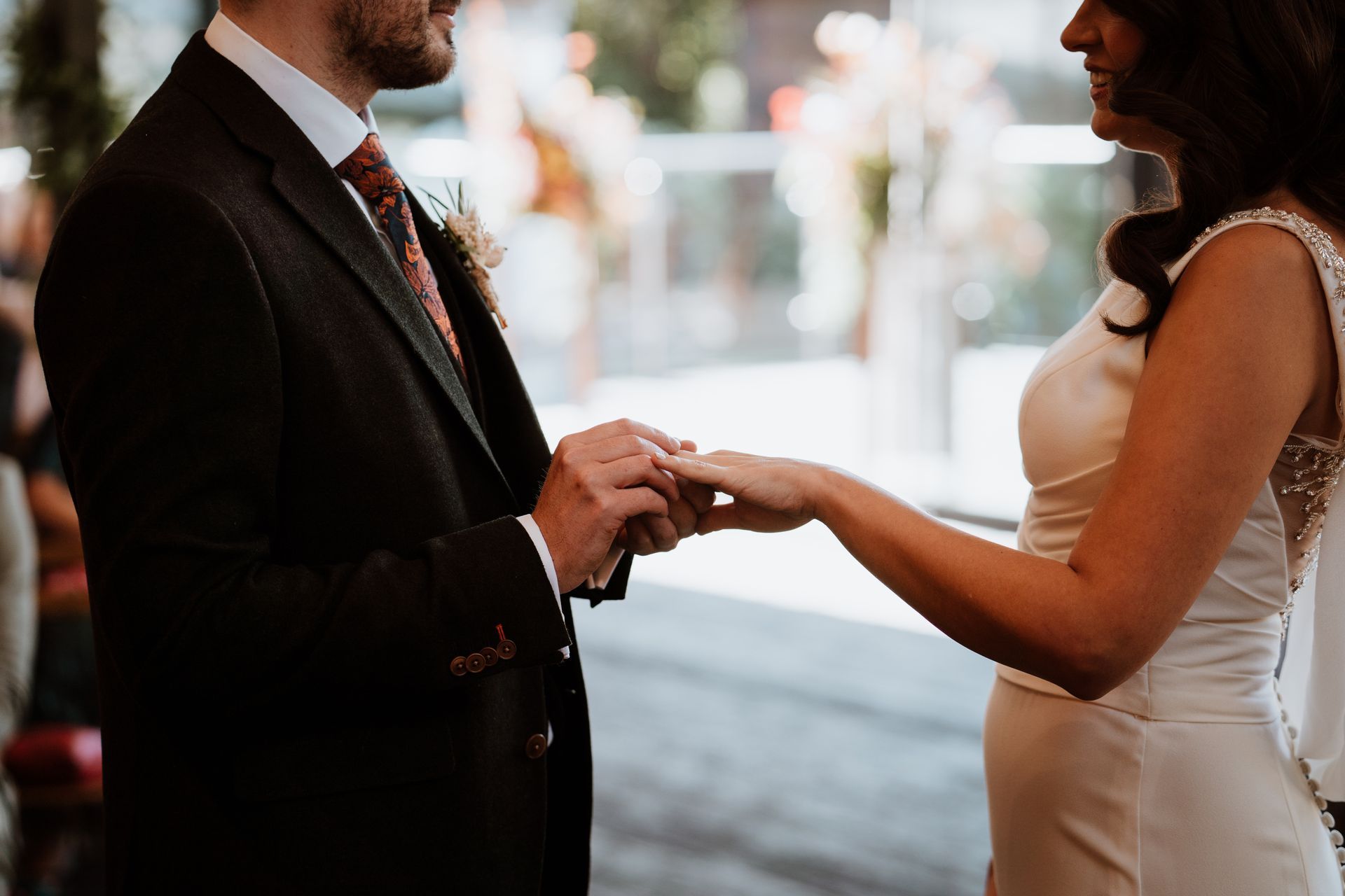 Bride and groom holding hands during an indoor wedding ceremony