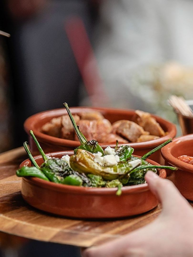 Handing a terracotta bowl of salad with green beans and white dressing at a table