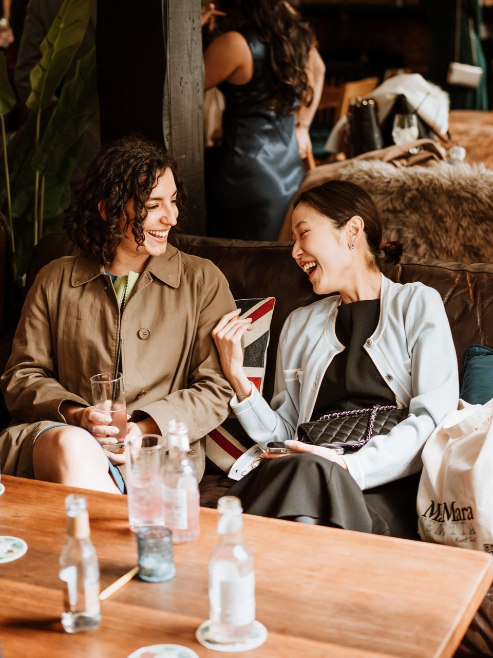 Two people chatting and smiling at a café table with drinks and menus