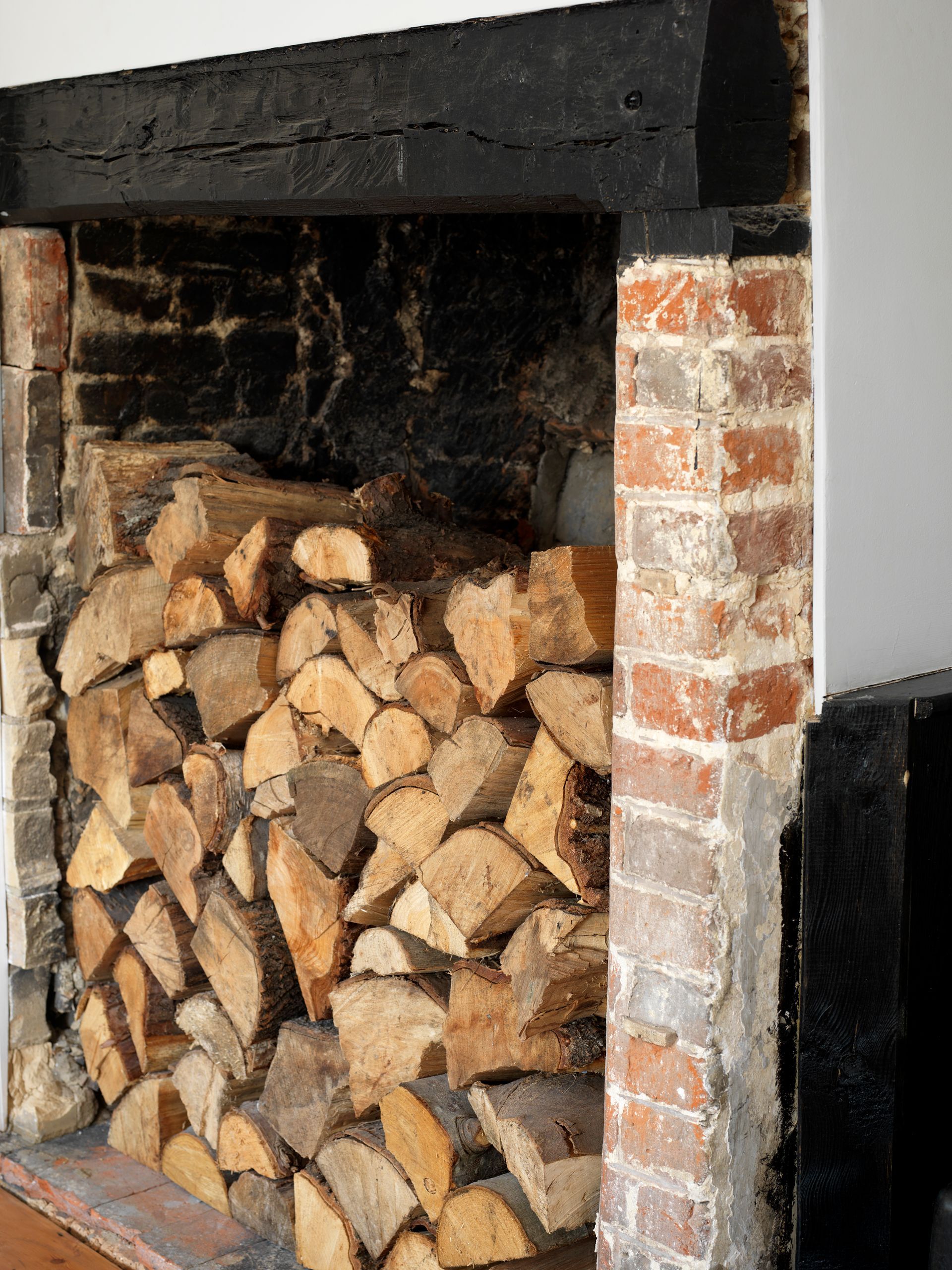 Stacked firewood inside a brick fireplace
