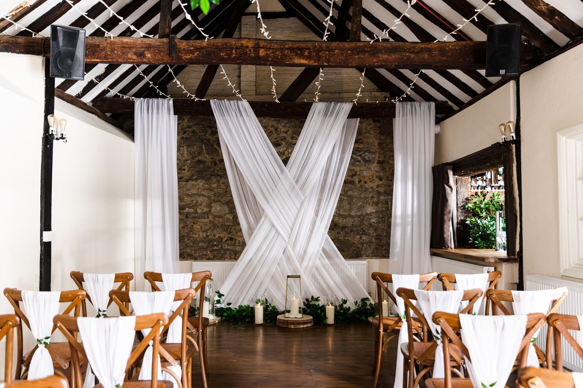 The Buttery decorated with white fabric across the brick wall