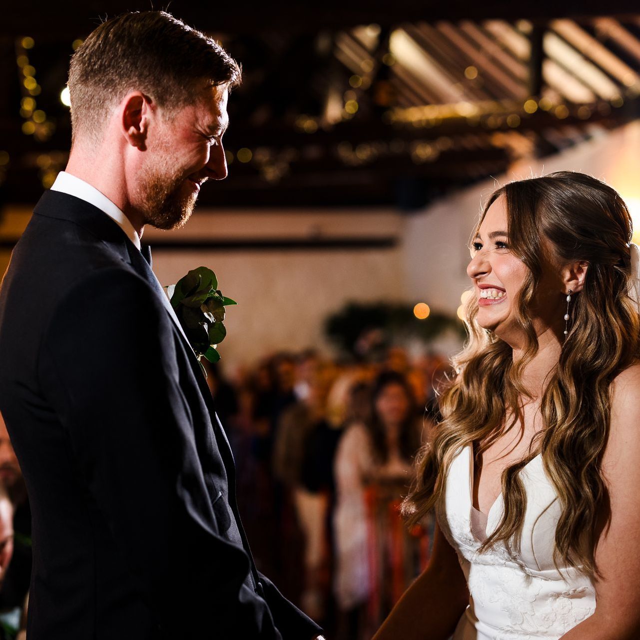 Bride and groom smiling at each other during a wedding reception