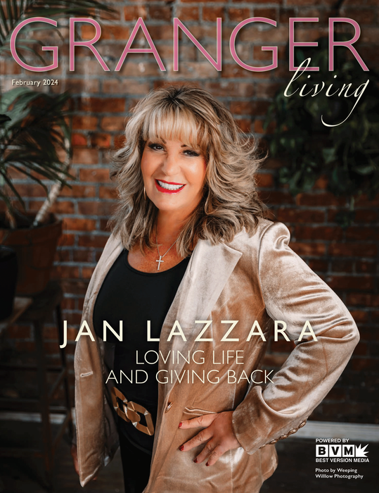 Woman, Jan Lazzara, on magazine cover. Smiling in gold jacket, in front of brick wall, with text