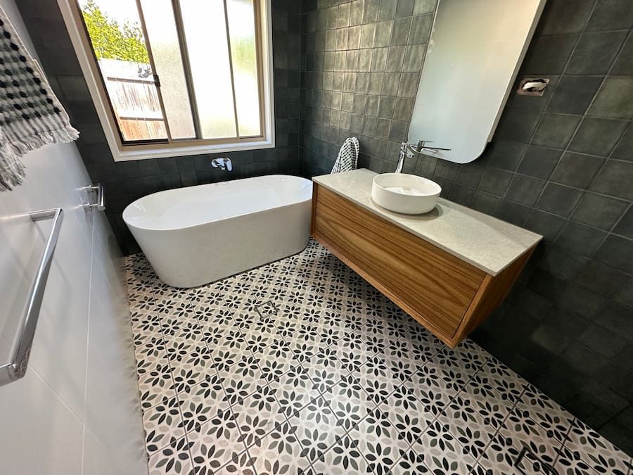 A Bathroom With A Bathtub, Sink And Mirror — Plumbmasters In Palm Beach, QLD