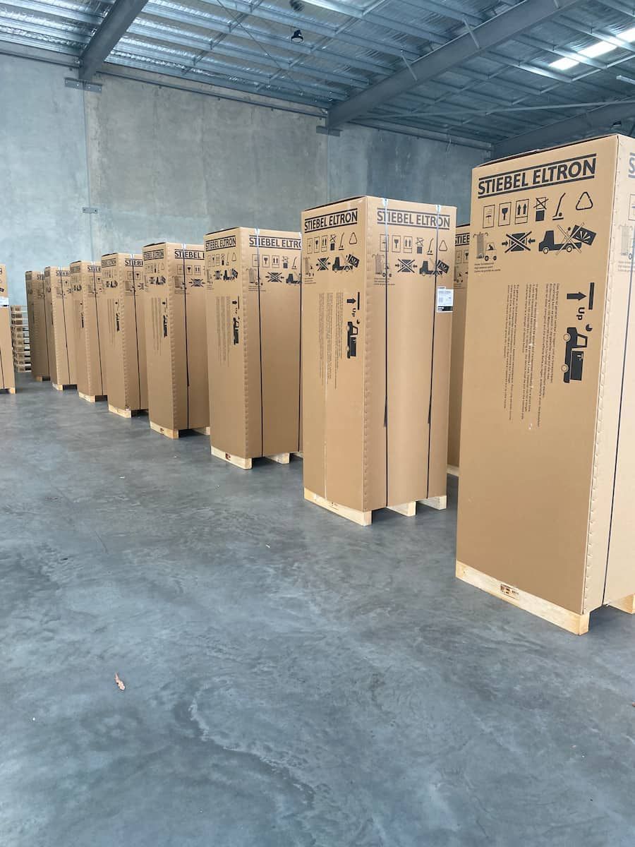 A Warehouse Filled With Lots Of Cardboard Boxes — Plumbmasters In Burleigh Heads, QLD