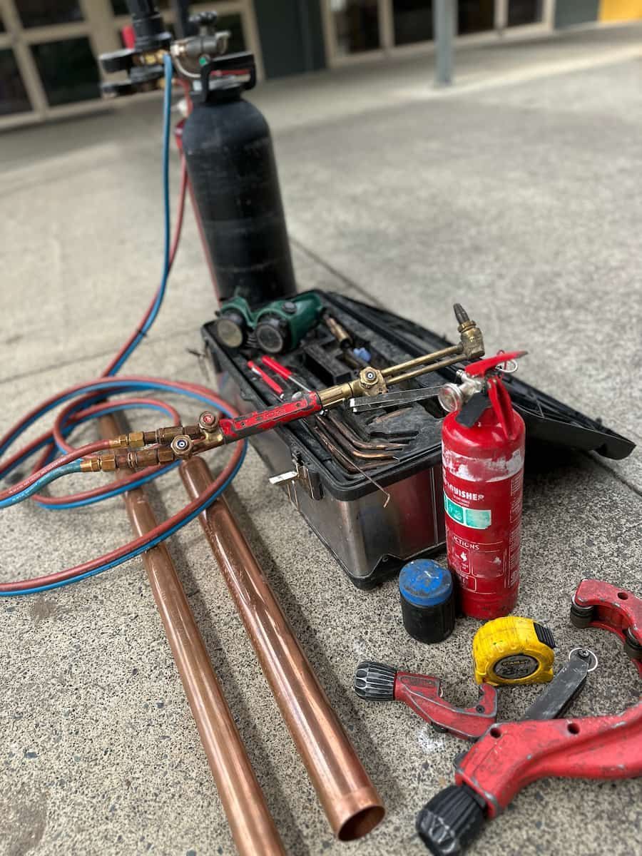 A Bunch Of Tools And Pipes Are Sitting On The Ground — Plumbmasters In Burleigh Heads, QLD