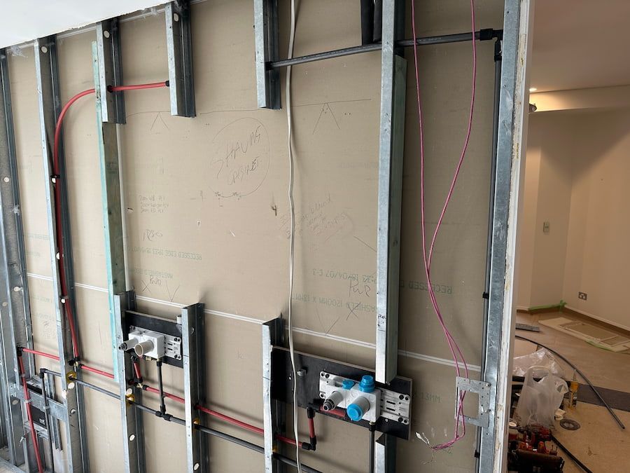 A Wall With A Lot Of Wires Coming Out Of It — Plumbmasters In Burleigh Heads, QLD