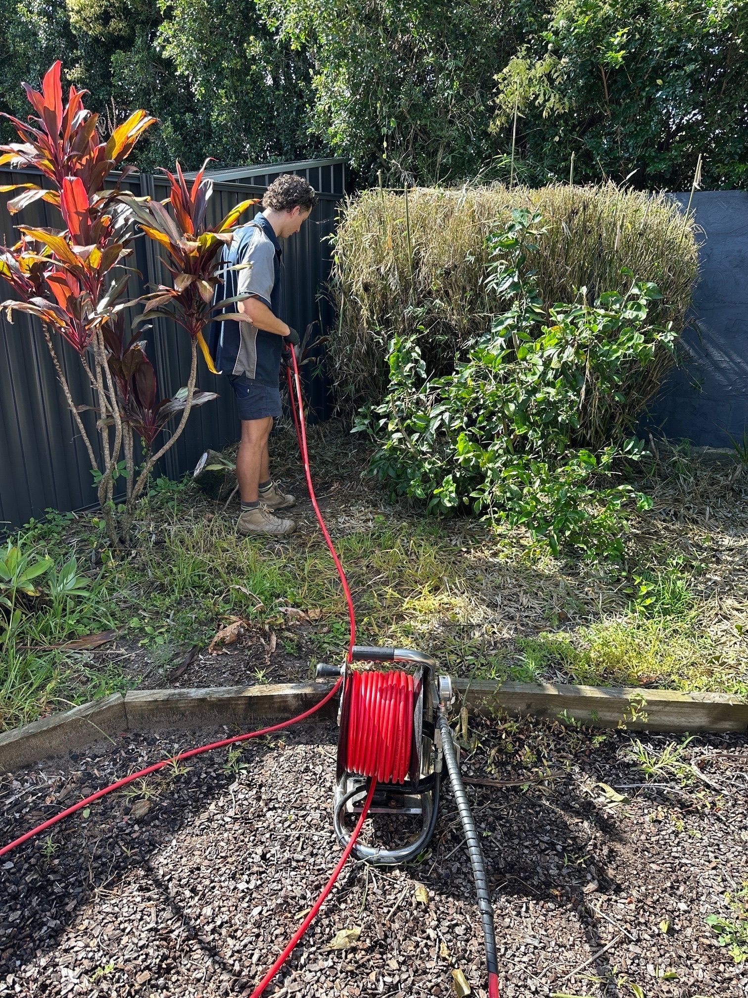 Plumbmasters using high-pressure water jetting equipment to clear a blocked drain on the Gold Coast