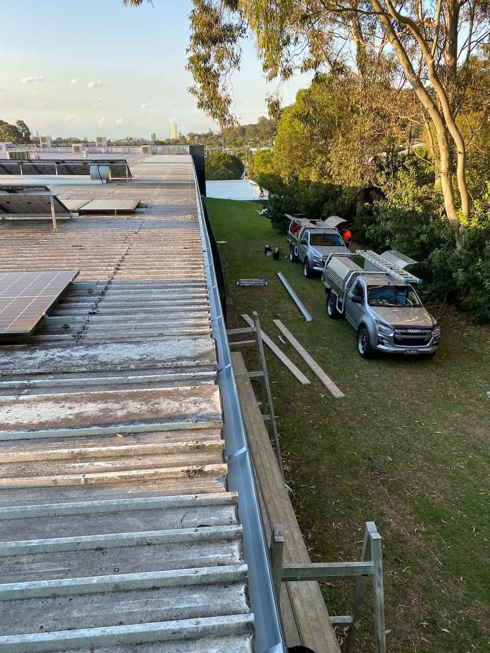 A Group Of Trucks Are Parked On The Side Of A Roof — Plumbmasters In Burleigh Heads, QLD