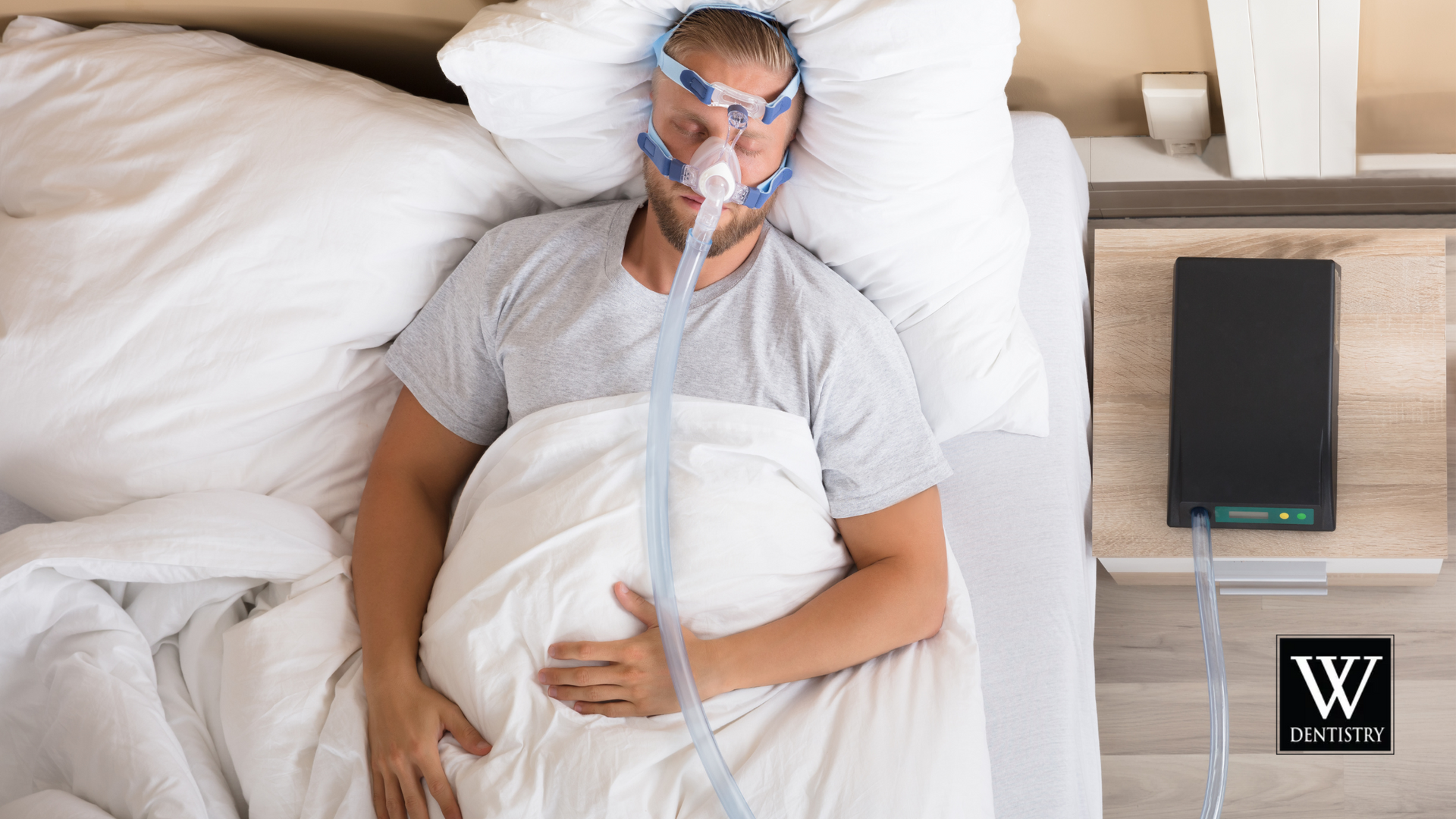 A man is sleeping in a hospital bed with an oxygen mask on his face.
