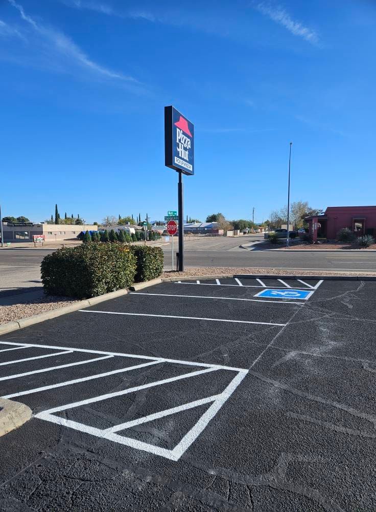 Accessible parking spaces in a mostly empty parking lot under a clear blue sky