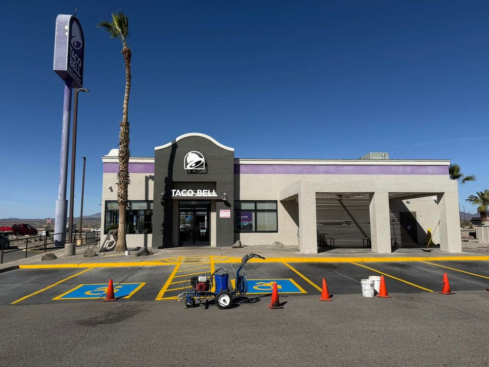 Drive-thru bank exterior with purple trim, clear blue sky, and traffic cones in front