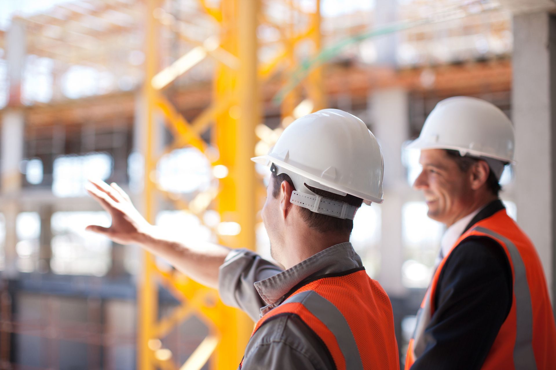 Due operai edili sono uno accanto all'altro in un cantiere edile.