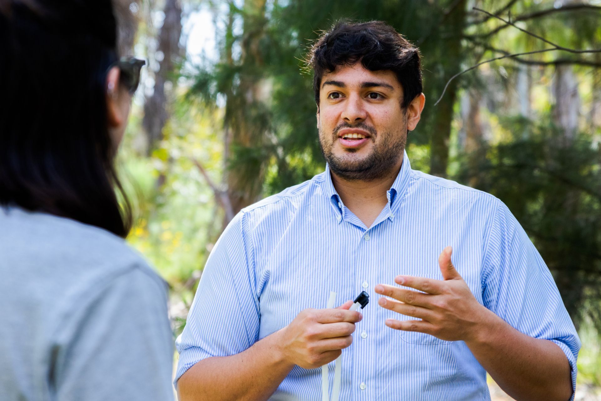 Alejandro speaking to another person whilst out in the field