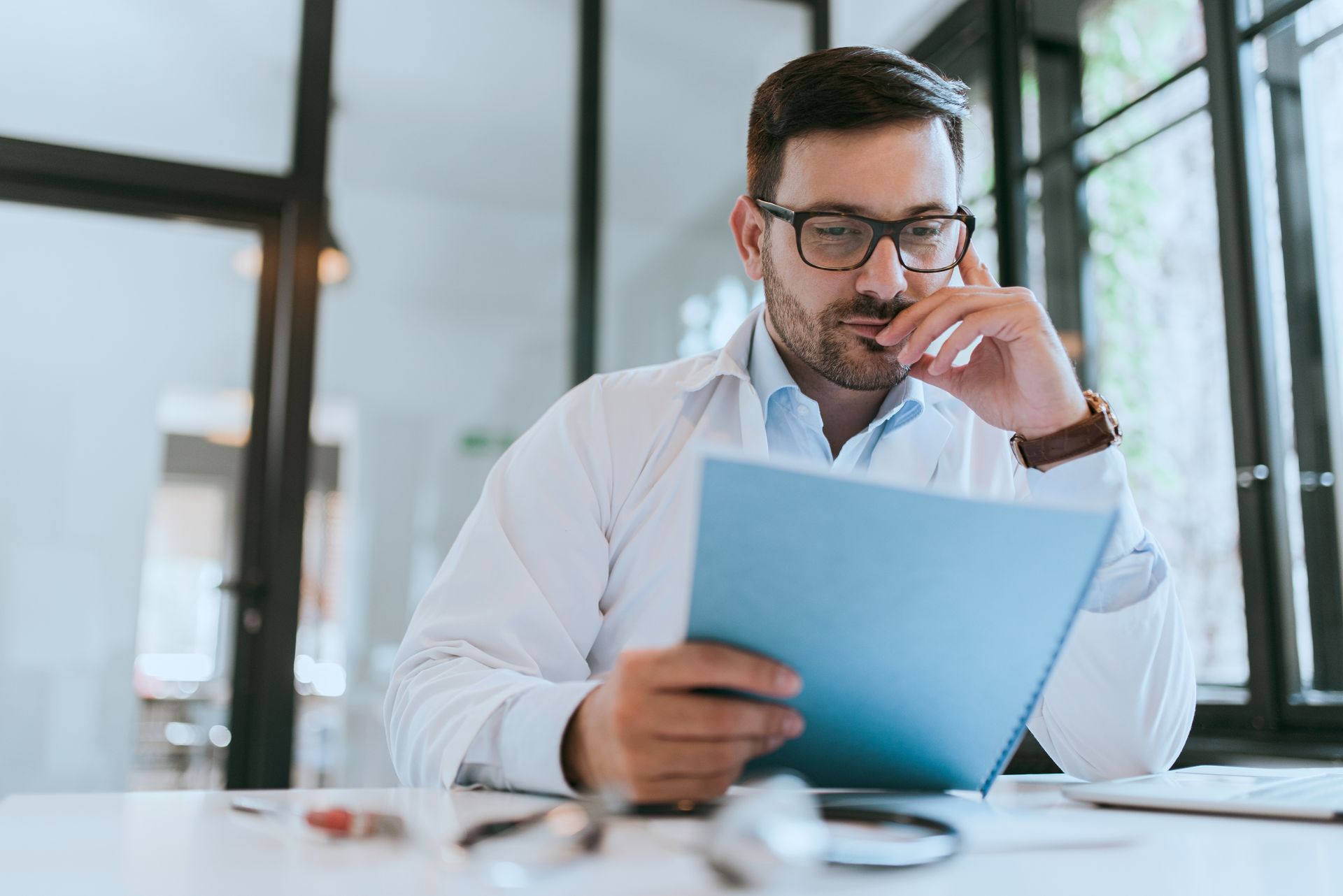 Person in lab coat looking at a document report