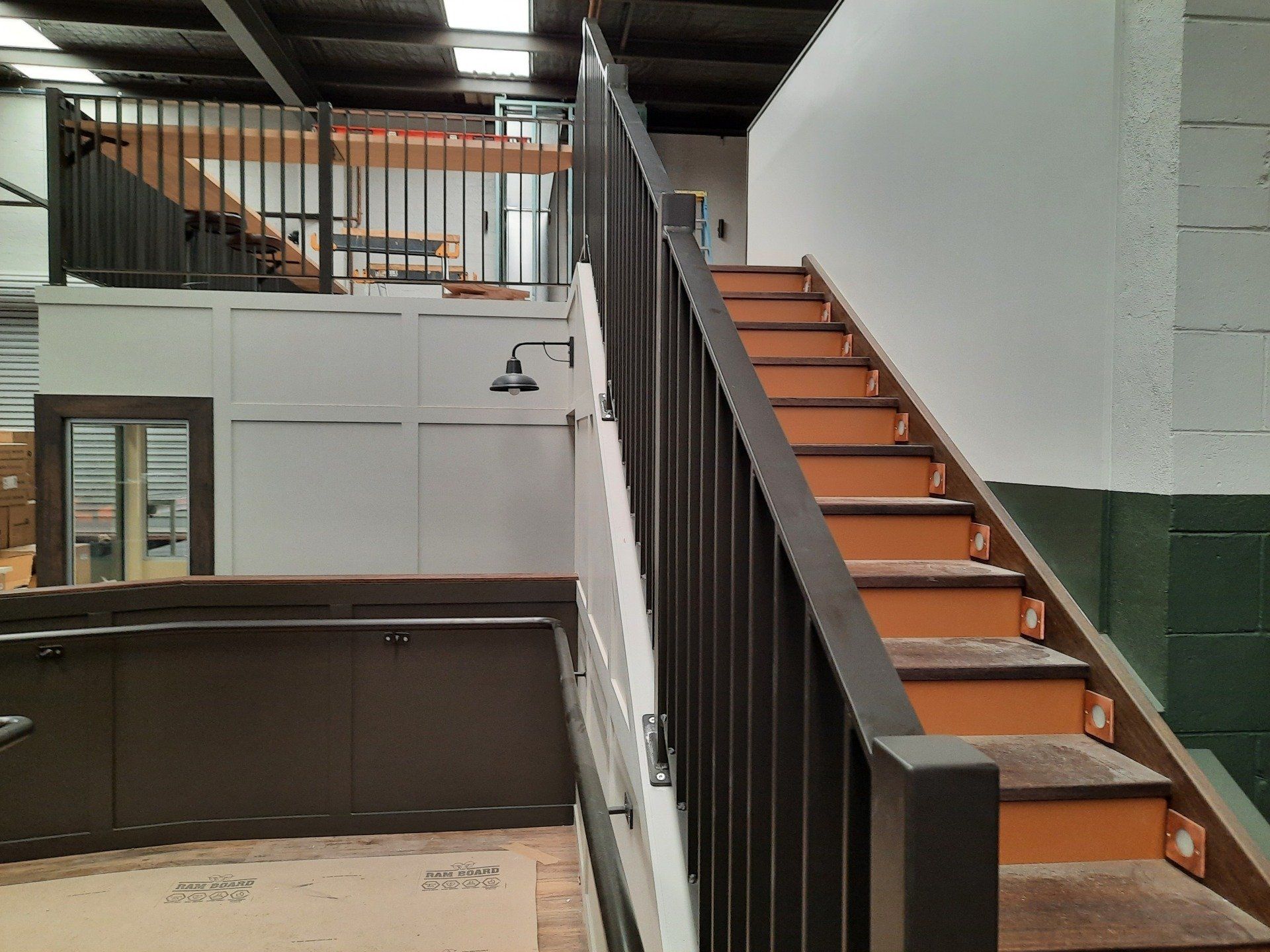 A Staircase In A Building With A Black Railing — Boambee Home Improvements in Coffs Harbour, NSW