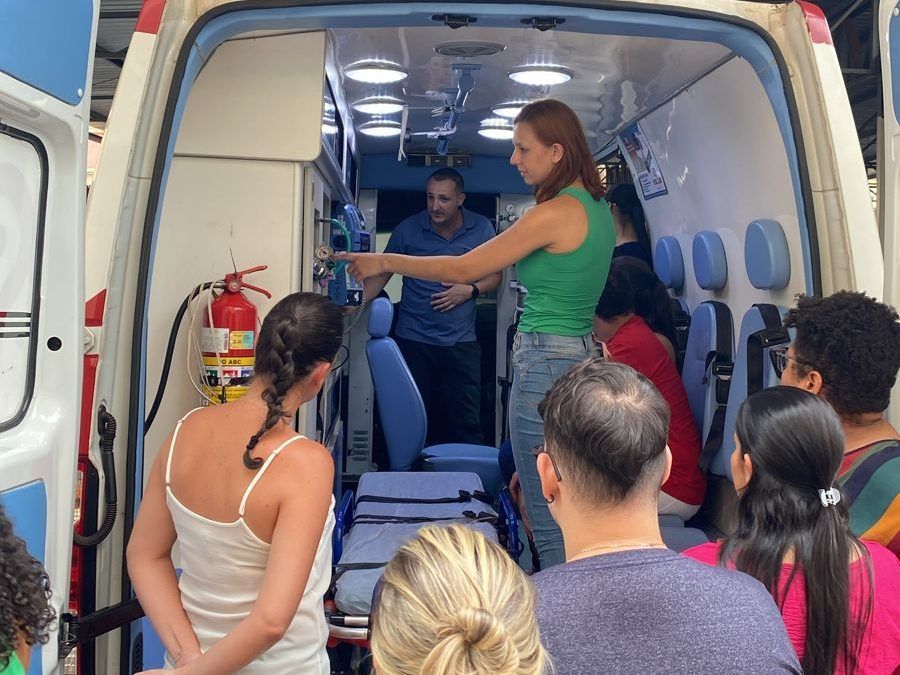 Instrutora mostrando os equipamentos de uma ambulância para alunos do Instituto Focar durante aula prática