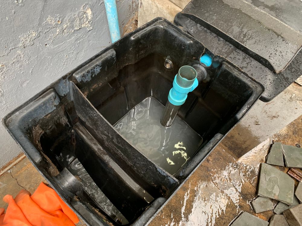 A Close Up of a Grease Trap With Water Coming Out of It — KYK Industries in Katherine, NT