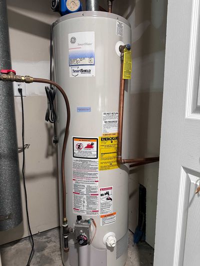 a water heater is sitting in a room next to a door.