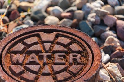 a rusty manhole cover with the word water written on it