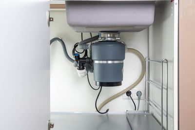 a kitchen sink with a garbage disposal underneath it.