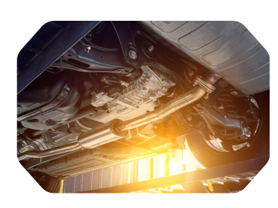 Underside of a car with a bright orange flame or spark near the exhaust
