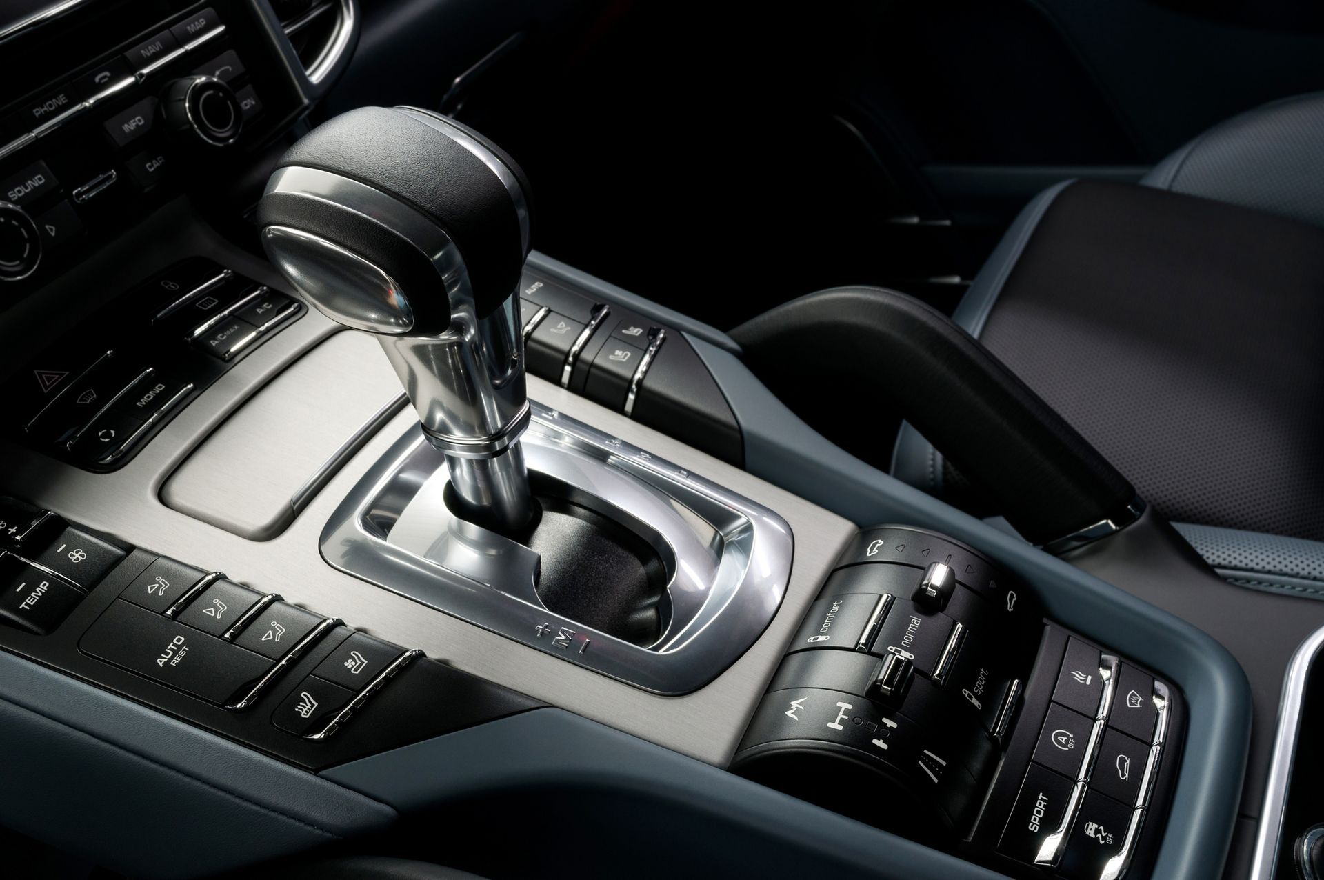 Close-up of a car’s center console with an automatic gear shift and control buttons.