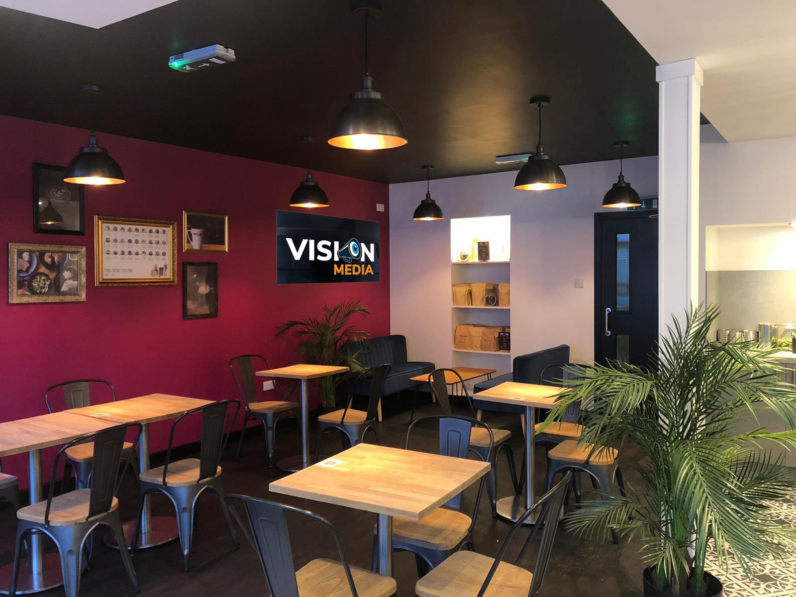 Cozy cafe interior with magenta walls, wooden tables, hanging lights, and potted plants