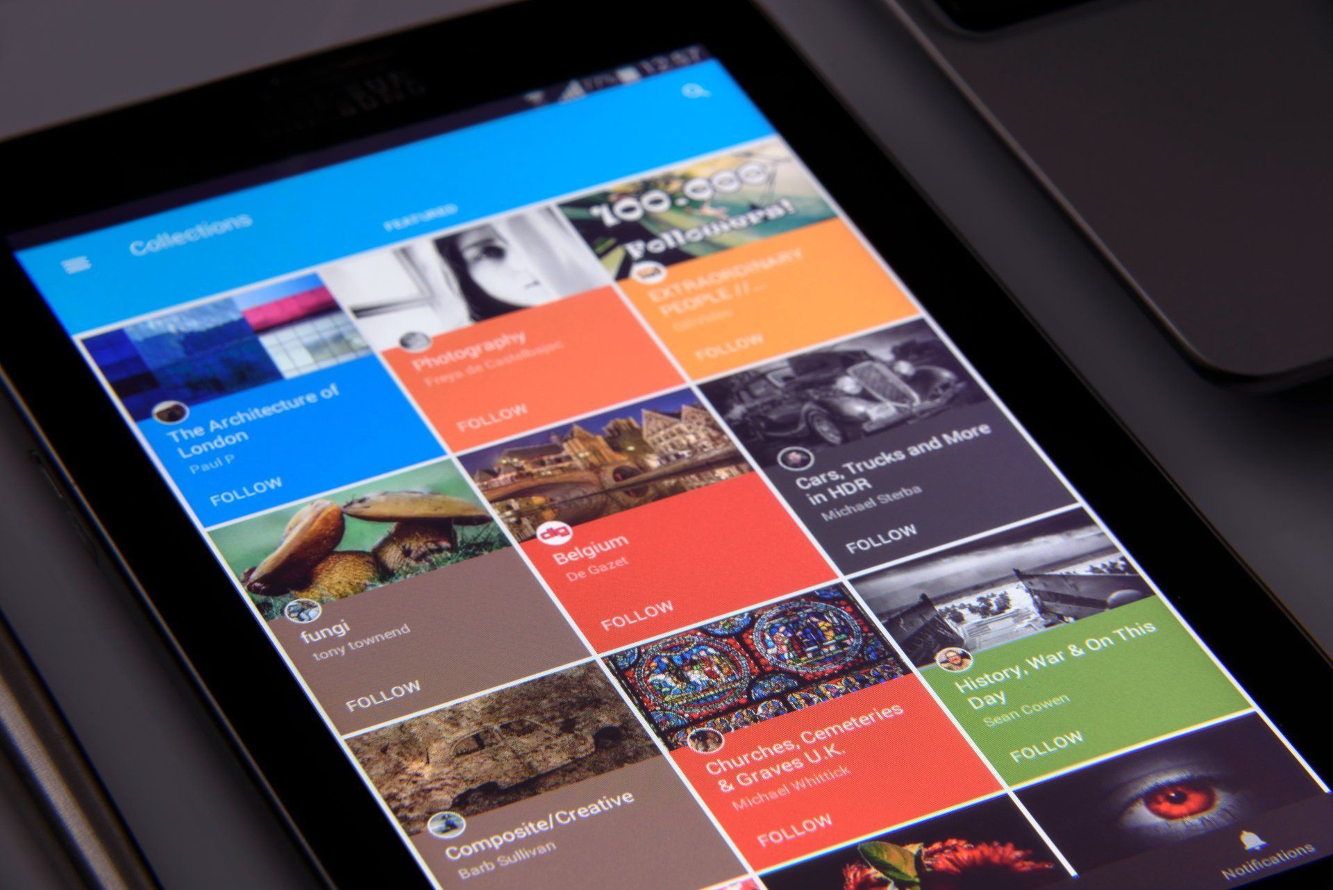 Tablet displaying a colorful app with image collections; various art, photography, and travel categories.